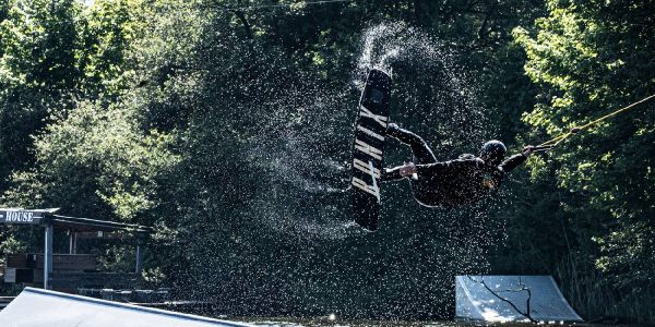 Im Gegenlicht glitzern die Wassertropfen beim Sprung dieses Wakeboarders. Foto: André Zand-Vakili Die Sonne lässt das Wasser bei großen Sprüngen glitzern